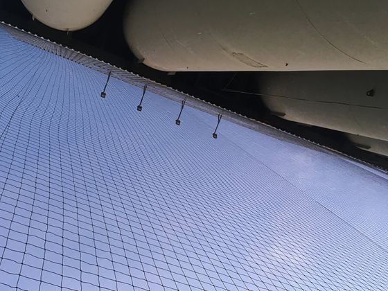 Großflächig gespanntes Vogelnetz an einer Industrieanlage von unten fotografiert